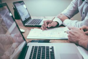 Biznesplan, który działa: Jak zaplanować sukces, a nie tylko wypełnić kartki? person holding pencil near laptop computer